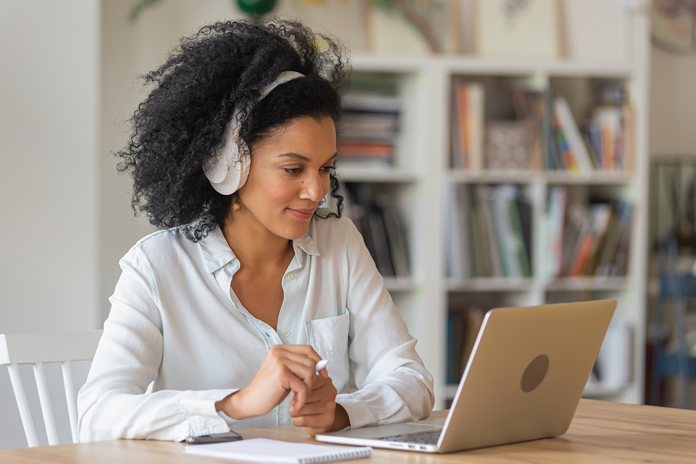 A woman wearing a headset and watching media on a laptop